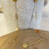 collier en acier inoxydable doré avec une asymétrie entre les pampilles rondes et ovales